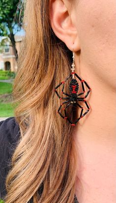 a close up of a person wearing spider earrings