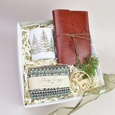 a gift box containing two notebooks, an ornament and a christmas tree