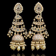 Preserve timeless charm into marvelous ensembles! With an absolute tale of elegance and sophistication, this pair showcases the beautiful composition of thapa kundan and beaded work with contemporary decorative pearl moti details adorned with true craftsmanship. Approximate earrings length is 4.5". Gold-plated on a high-quality brass as base metal. Made by order. Kindly allow 4-6 weeks for the delivery of this item. For custom or urgent requests, please contact support@alacouture.com. *Please No Festive Temple Jewelry Pearl Earrings With Stone Work, Temple Jewelry Style Danglers With Stone Work For Reception, Reception Temple Jewelry Danglers With Stone Work, Silver Kundan Jhumkas With Pearl Drop, Chandbali Kundan Necklace With Pearl Drop, Kundan Chandbali Necklace With Pearl Drop, Traditional Pearl Earrings With Stone Work For Festive Season, Pearl Drop Temple Jewelry Danglers For Reception, Traditional Festive Pearl Earrings With Stone Work