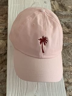 Description: Escape to a tropical paradise with our Personalised Embroidered Palm Tree Cap. This cap is a must-have accessory for beach lovers and nature enthusiasts, providing a stylish way to embrace the laid-back vibes. The front of the cap features a beautifully embroidered palm tree design, instantly transporting you to sandy beaches and sunny days. Choose from a variety of cap colours, including beige, mint green, pale blue, navy, pink, lemon, and black, to match your personal style. Personalisation: Make this cap truly unique by customising the colour of the front embroidery. Choose your preferred colour from our available options to create a cap that perfectly reflects your tropical paradise. Additionally, you can add your name or initials with our optional back embroidery. Simply Cotton Snapback Hat For Vacation, Casual Beach Dad Hat Visor, Casual Beach Visor Dad Hat, Casual Visor Dad Hat For Beach, Beach Dad Hat With Embroidered Logo, Casual Beach Baseball Cap With Embroidered Logo, Casual Embroidered Baseball Cap For Beach, Summer Travel Hat With Curved Bill, Casual Visor Baseball Cap For Vacation