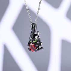 Playful, inquisitive and intelligent, this fictional dragon is indisputably special. Beautifully handcrafted in sterling silver, this necklace in Hug Me® collection features a brilliant heart cut stone hugged by a dragon, which is designed to be so lovely and super-cute. His 3D wings, ears and bright green eyes are captured in amazing detail as he on your neck. You will find more adorable and creative designs in our Hug Me® collection.Carat Weight: 1.4 ctStone Size: 6*6 mmStone Type: Jeulia® Sto Dragon Design Round Pendant Necklace For Gift, Dragon Design Round Pendant Necklace As A Gift, Unique Sterling Silver Necklace With Dragon Design, Fantasy Sterling Silver Pendant Jewelry, Black Dragon Design Jewelry Gift, Black Jewelry With Dragon Design For Gift, Collectible Pendant Jewelry For Valentine's Day, Silver Dragon Design Jewelry Gift, Black Fantasy Necklace For Gift