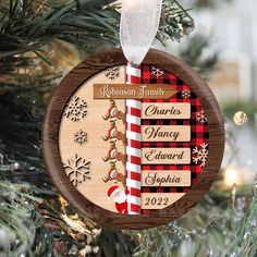 a personalized christmas ornament hanging on a tree with snowflakes and candy canes