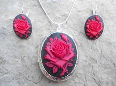 For sale are perfectly detailed, flawless (red rose with a single bud on a black background) cameo pendant silver plated LOCKETS!!!! Gorgeous!!! About 1 3/4" long!!! They hold two photos inside (or keepsakes). The French Earrings are also silver plated, about 1" long and very nice quality!!  They are offered at a reasonable price, make perfect gifts, and are wonderful quality!!!!  and the chain is 22" .925 silver plated 1.2mm snake chain, with a lobster claw clasp!!!! Please do visit my shop!!! Valentine's Day Rose Design Party Jewelry, Rose Red Roses Jewelry For Valentine's Day, Red Rose Design Jewelry For Mother's Day, Black Rose Design Party Jewelry, Rose Red Roses Jewelry For Weddings, Rose Red Jewelry With Roses For Wedding, Valentine's Day Formal Jewelry With Roses, Formal Valentine's Day Jewelry With Roses, Rose Red Wedding Jewelry With Roses