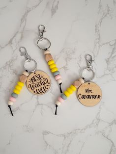 two wooden key chains with personalized charms