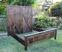 a bed frame made out of wooden boards and slats sitting in the middle of a yard