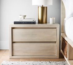 a nightstand with books and candles on it