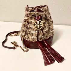 Tory Burch 80597 Fleming Soft Tweed Mini Bucket Bag Org $398. 100% Authenticity Guarantee! This Item Is Sourced From Tory Burch. Product Description Tory Burch Fleming Mini Bucket Bag Is Made Of A Mix Of Tweed And Leather With Oversized Diamond Quilting And A Double-T Charm. The Drawstring Pouch Is Finished With Tassels, And A Strap Braided With Brushed Gold Chain. Tweed, Leather Drawstring Closure For All Large Phone Sizes Adjustable Metal Chain Strap With 22.3" (56 Cm) Drop. Leather Shoulder G Silky Black Hair, Pale White Skin, Shoulder Guard, Tory Burch Fleming, Mini Bucket Bag, Out Of Nowhere, Mini Bucket Bags, Mini Bucket, White Skin