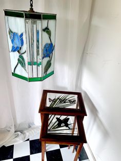 two stained glass vases sitting on top of a checkered floor next to a table