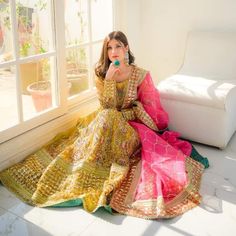 a woman sitting on the floor in a colorful dress