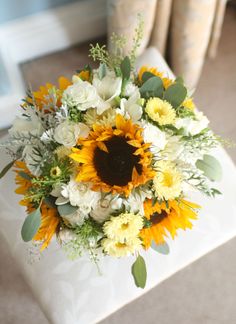 a bouquet of sunflowers and other flowers on a table