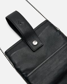 At.Kollektive x Kiko Kostadinov pouch in black. This pouch is made from Ecco leather and features hook fastening with snaps, a bungee cord detail and a shoulder strap. Black Leather Pouch For On-the-go, Leather Phone Bag With Snap Closure For Travel, Leather Phone Bag With Snap Closure Crossbody, Leather Crossbody Phone Bag With Snap Closure, Black Shoulder Bag With Gunmetal Hardware For Everyday, Black Leather Pouch For Mobile Phone, Functional Leather Shoulder Bag With Snap Closure, Black Leather Pouch With Detachable Strap, Black Leather Pouch With Adjustable Strap