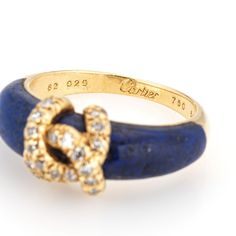 Vintage "Double C" Cartier diamond ring crafted in 18k yellow gold.    Diamonds total an estimated 0.15 carats (estimated at G-H color and VS2-SI1 clarity). Lapis lazuli tapers and measures from 6mm to 4.5mm. Note: some wear to the lapis (surface abrasions) and a small fissure underneath the CC logo (visible under a 10x loupe).    The elusive 'Double C' ring is a classic made by Cartier in the 1970s. Diamonds adorn the 'CC' motif, perched upon rich cobalt blue lapis lazuli. The ring is great worn alone or stacked with your fine jewelry from any era and would also make a unique choice as an alternative wedding ring. The intertwining 'Cs' make a nice representation of a couple joining together as one. The ring does not come with Cartier papers or a box.   The ring is in good condition and wa Vintage Cartier Diamond Jewelry, Cartier Yellow Gold Jewelry With Diamond Accents, Cartier Yellow Gold Diamond Ring With Accents, Designer Yellow Gold Brilliant Cut Diamond Ring, Designer Yellow Gold Diamond Ring With Brilliant Cut, Cartier Designer Yellow Gold Jewelry, Designer Cartier Yellow Gold Jewelry, Designer Yellow Gold Cartier Jewelry, Cartier 14k Stamped Formal Rings