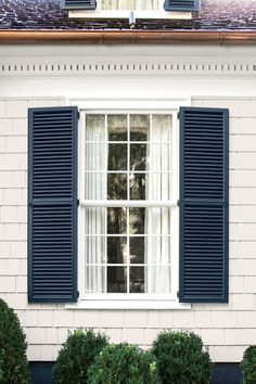 a white house with black shutters and windows