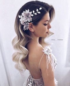 a woman with long blonde hair and flowers in her hair, wearing a white dress