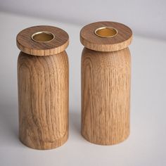 two wooden salt and pepper shakers sitting side by side on a white table top