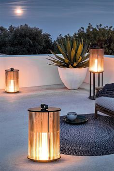 a bed sitting on top of a white floor next to two large planters filled with plants