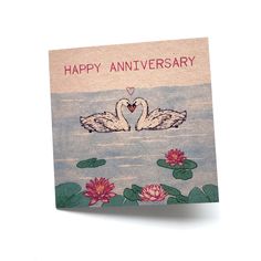 a happy anniversary card with two swans floating on water