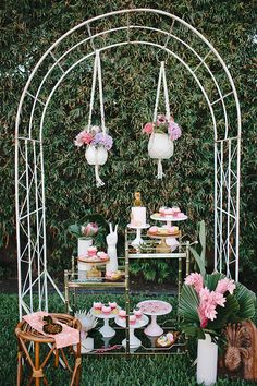 an outdoor dessert table set up with pink flowers