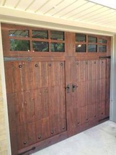 two wooden garage doors with windows on each side