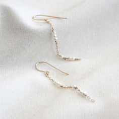 Dainty pearl chain dangle earrings. They are so simple and minimal that they would go with any outfit! Every piece is handcrafted in NYC, and pearls are natural, so shapes and colors may be slightly different from each other. These earrings will be made for you after the order is placed. The item will either be packaged in a jewelry pouch or in a jewelry gift box. Perfect as a gift! MATERIALS 14k gold filled Freshwater pearlsSilicone ear nuts DIMENSIONS approx. 2 3/4" (60mm) length Dainty Pearl Charm Dangle Threader Earrings, Dainty Dangle Threader Earrings With Pearl Charm, Delicate Pearl Chain Dangle Earrings, White Pearl Drop Threader Earrings, Dainty Pearl Dangle Linear Earrings, Dainty Pearl Drop Linear Earrings, Minimalist Pearl White Pearl Chain Earrings, Delicate 14k Gold Filled Earrings With Pearl Chain, Dainty Everyday Pearl Earrings