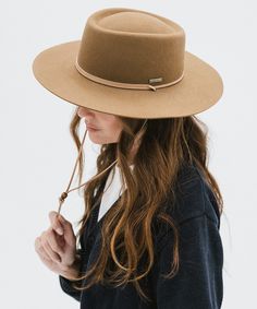 a woman wearing a brown hat and black shirt