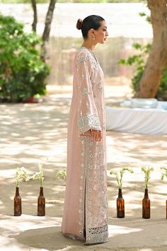 "A contemporary take on a classic kaftan silhouette, cut from tissue, in an elegant shade of blush pink. Dispersed kamdani and zardoze details with a cutworked hem elevate the look." Elegant Pink Kurta With Dabka Work, Elegant Pink Kurta With Resham Embroidery, Pink Kaftan With Dabka Work For Wedding, Elegant Pink Kurta With Sheer Dupatta, Pink Wedding Kaftan With Dabka Work, Elegant Pink Kurta For Eid, Elegant Pink Gown With Dabka Work, Elegant Wedding Kaftan With Sheer Dupatta, Elegant Kaftan With Chikankari Embroidery For Wedding