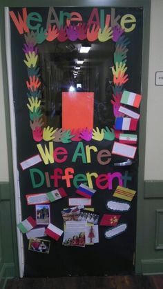 a door decorated with handprints and words that say we are alive, we are different