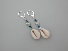 Surprise your beach-loving friend with a birthday gift that whispers of sunshine and sand!  These stunning silver plated leverback earrings feature genuine cowrie shells, for a real connection to the sea and a symbol of good luck. Delicate glass green seed beads add a touch of colour, while a textured silver plated heart charm whispers "love" for the beach.   Made with high-quality components, these earrings are perfect for everyday wear or adding a touch of coastal charm to a special occasion. Cowrie Shell Earrings, Real Connection, Beach Jewellery, Seashell Earrings, Cowrie Shells, Coastal Charm, Leverback Earrings, Cowrie Shell, Birthday Gift For Her