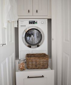 a washer and dryer sitting on top of a cabinet in a laundry room