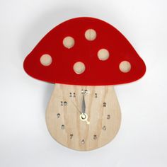 a wooden clock with a red mushroom on it