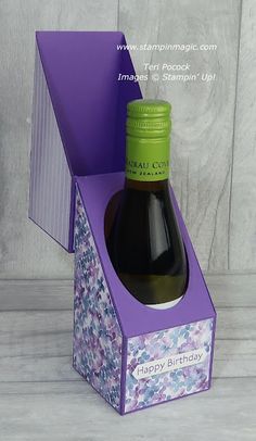 a bottle of wine in a purple gift box