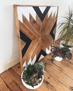 two potted plants sit on top of a wooden table in front of a wood paneled wall