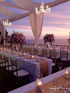 an outdoor dining area with tables and chairs set up for a formal function at dusk