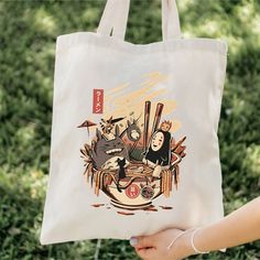 Our Ghibli Inspired Ramen 100% cotton bag comes in one size - 15" x 16"- perfect for everyday wear. While the canvas material will show off your designs in great colors, it's durable and will last for years. The bag features 20" handles (made from the same canvas), making it easy to carry even with a week's worth of shopping in Ghibli inspired style! .: 100% cotton canvas .: Heavy fabric (12 oz/yd² (406.9 g/m .: Sewn-in label Casual Cotton Canvas Bag With Eco-friendly Ink, Eco-friendly Canvas Bag With Graphic Print, Casual Canvas Bag With Eco-friendly Ink For Daily Use, Daily Use Canvas Bag With Eco-friendly Ink, Eco-friendly Graphic Print Canvas Bag, Cotton Shoulder Bag With Graphic Print, Daily Use Cotton Shoulder Bag With Graphic Print, Casual Canvas Softback Bag For Gift, Casual Canvas Softback Bag As A Gift