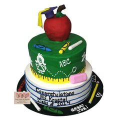 there is a cake that has an apple on top and school supplies on the bottom