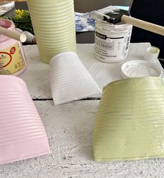 some pink and white vases sitting on top of a table