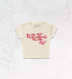 It's Me, Hi, I'm The Problem It's Me with our Taylor Swift inspired 70's retro baby tshirt!- Features lyrics from the song "Anti Hero" with butterflies around it all in light pink and deep red or blue and orange ink- Screen print transfer that is heat pressed onto each tshirt- Tshirt is a super soft, 90s style micro ribbed baby tee- Regular Baby Tee Fit - Cotton / Poly**due to screens & filters color may vary from pictures** Taylor Swift Baby Tee, Pink Baby Tee, Ours Taylor Swift, Taylor Swift Inspired, Screen Print Transfer, Anti Hero, Retro Baby, Print Transfer, Baby Tees