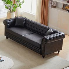 a living room with a black leather couch and white rug on top of the floor