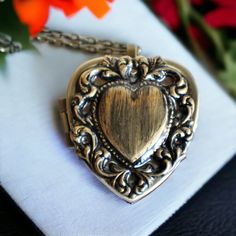 "Heart music box pendant. This heart shaped music box is inspired by the gorgeous music box pendants of era's gone by. Music box is pill box size, please look at the dimensions for exact size.  A heart shaped locket has been adorned with a bronze stamping of a lacey edged floral heart with a solid heart center. The lacey edged floral heart has been covered in a clear resin to give a glass like finish and preserve the beauty of this musical pendant.  The locket opens and closes by pushing the little button on the side and reveals a tiny working music box that plays an 18 note musical tune.  Choose the music box tune you would like at checkout.To listen to the music box tunes, get more information on our music boxes and see our limited addition tune list, go to http://bit.ly/1VJ9Amj  The ins Elegant Medallion Heart Necklace As A Gift, Elegant Medallion Locket Necklace For Valentine's Day, Elegant Heart Necklace With Vintage Charm As Gift, Vintage Heart Pendant Charm Jewelry For Keepsake, Vintage Charm Heart Pendant Jewelry For Keepsake, Victorian Brass Necklace With Heart Charm, Elegant Vintage Charm Locket Necklace For Valentine's Day, Elegant Brass Locket Necklace For Valentine's Day, Elegant Double Heart Locket Necklace Gift