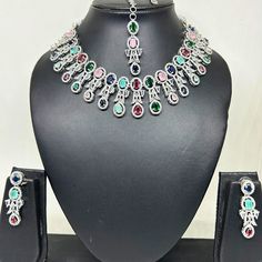 Elevate your style and celebrate the timeless beauty of Indian tradition with this exquisite Premium AD Necklace Set. This enchanting jewelry ensemble is a perfect blend of traditional and contemporary design, making it a stunning addition to any special occasion or a thoughtful gift for a loved one. Product Details: Premium AD Necklace: Our meticulously crafted necklace features a stunning pendant adorned with American Diamond (AD) crystals, adding a touch of elegance and charm. The necklace sh Silver Temple Jewelry Bridal Set For Festive Occasion, Elegant Multicolor Bridal Sets For Festive Occasions, Elegant Multicolor Sets With Stone Work, Formal Multicolor Bridal Necklace, Silver Temple Jewelry Sets For Celebration, Elegant Multicolor Bridal Sets With Stone Work, Elegant Multicolor Wedding Sets, Festive Silver Jewelry Sets With Elegant Design, Festive Silver Jewelry Sets For Anniversary