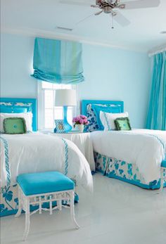 two beds in a room with blue and white decor