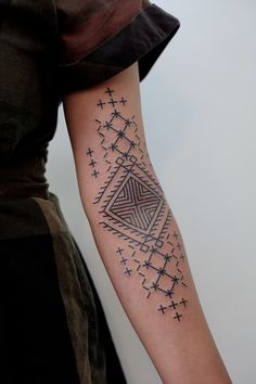 black and white photo of a woman's arm with an intricate tattoo design on it