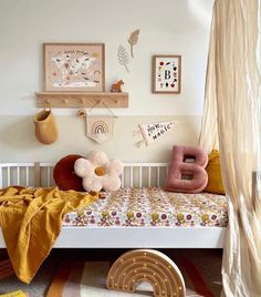 a child's bedroom with a bed, rugs and pictures on the wall