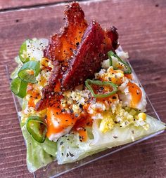 there is a salad with bacon on it and other toppings in the glass dish