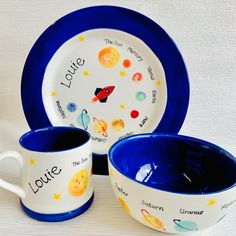 two cups and saucers with the names of different planets on them, sitting next to each other