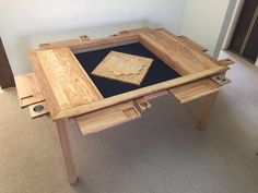 a table made out of wood with a black mat on top and two pieces of wood in the middle