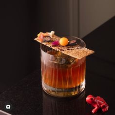 a glass filled with liquid sitting on top of a counter next to a red object