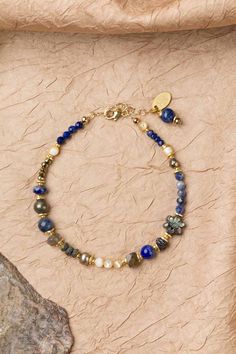 Discover the vibrant and stunning colors of the Blue Moon Collection in this eclectic bracelet! Gold Filled (Lead & Nickel Free) Pyrite, Lapis Lazuli, Sodalite, Abalone, Labradorite, Freshwater Pearl, Mother Of Pearl 7.5-8.5" adjustable length, with gold filled lobster claw clasp We hand select our natural materials, thus there may be slight variations in color and/or size that will not detract from the overall aesthetic. Our unique handcrafted designer jewelry for women is made in America, each Luxury Lapis Lazuli Bracelets, Blue Bohemian Gemstone Bracelets, Bohemian Blue Gemstone Bracelets, Blue Fusion Style Beaded Bracelets As Gift, Fusion Style Blue Beaded Bracelets Gift, Fusion Style Blue Beaded Bracelets For Gift, Blue Fusion Style Bracelet As A Gift, Blue Fusion Style Bracelet As Gift, Blue Fusion Style Bracelet For Gifts