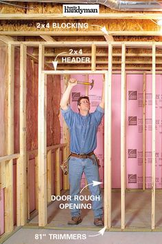 a man standing in the middle of a room with framing around him and holding a hammer