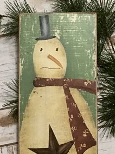 a wooden sign with a snowman wearing a top hat and scarf on it's head